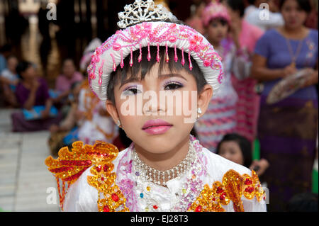 Ein Junge Burmesische gekleidet in bunten Gewändern und Puppe wie sein kommen der Alter Zeremonie in Mandalay Myanmar ausgleichen Stockfoto