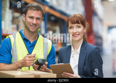 Arbeiter und Manager, die Scan-Paket im Lager Stockfoto