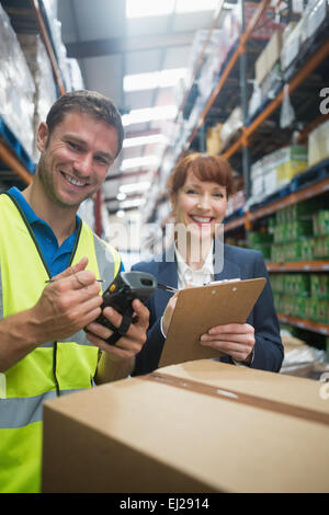 Arbeiter und Manager, die Scan-Paket im Lager Stockfoto