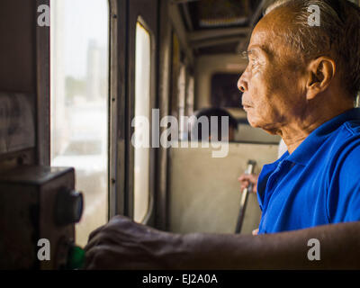 Ayutthaya, Ayutthaya, Thailand. 19. März 2015. Ein Personenzug auf eine dritte Klasse in der Nähe von Ayutthaya. Die Bahnlinie von Bangkok nach Ayutthaya war die erste Eisenbahn in Thailand gebaut und wurde im Jahre 1892 eröffnet. Die staatliche Eisenbahn von Thailand (SRT), gegründet 1890, betreibt 4.043 Kilometer Meter Messgerät, das meisten Teilen von Thailand erreicht. Viel von der Strecke und viele der Züge sind in schlechtem Zustand und Züge fahren häufig spät. Unfälle und Pannen sind ebenfalls üblich. Aufeinanderfolgende Regierungen, einschließlich der aktuellen militärischen Regierung haben versprochen, Bahnverkehr zu aktualisieren. Die mili Stockfoto