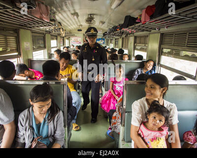 Ayutthaya, Ayutthaya, Thailand. 19. März 2015. Der Dirigent die dritte Klasse Zug von Ayutthaya nach Bangkok Fahrgäste Tickets kontrollieren. Die Bahnlinie von Bangkok nach Ayutthaya war die erste Eisenbahn in Thailand gebaut und wurde im Jahre 1892 eröffnet. Die staatliche Eisenbahn von Thailand (SRT), gegründet 1890, betreibt 4.043 Kilometer Meter Messgerät, das meisten Teilen von Thailand erreicht. Viel von der Strecke und viele der Züge sind in schlechtem Zustand und Züge fahren häufig spät. Unfälle und Pannen sind ebenfalls üblich. Aufeinanderfolgende Regierungen, einschließlich der aktuellen militärischen Regierung haben pr Stockfoto