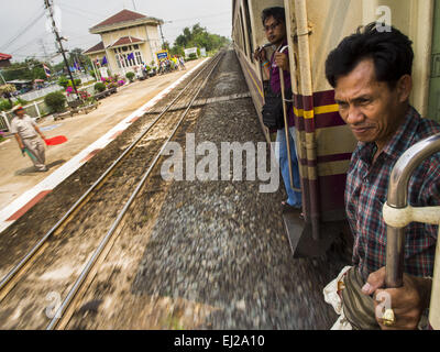 Ayutthaya, Ayutthaya, Thailand. 19. März 2015. Ein Mann bereitet sich vor, die Ayutthaya Bangkok dritte Klasse Zug zu verlassen, wie der Zug in Bang Pa In-Station in der Nähe von Ayutthaya zieht. Die Bahnlinie von Bangkok nach Ayutthaya war die erste Eisenbahn in Thailand gebaut und wurde im Jahre 1892 eröffnet. Die staatliche Eisenbahn von Thailand (SRT), gegründet 1890, betreibt 4.043 Kilometer Meter Messgerät, das meisten Teilen von Thailand erreicht. Viel von der Strecke und viele der Züge sind in schlechtem Zustand und Züge fahren häufig spät. Unfälle und Pannen sind ebenfalls üblich. Aufeinanderfolgende Regierungen, einschließlich der Stockfoto