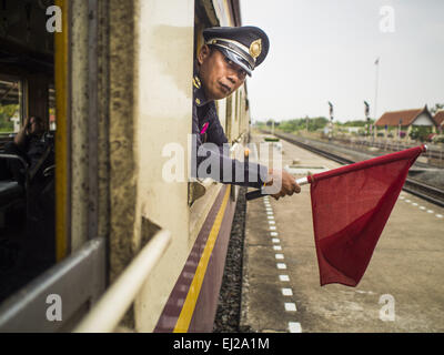 Ayutthaya, Ayutthaya, Thailand. 19. März 2015. Ein Conductorleans aus dem Fenster von Ayutthaya, Bangkok dritte Klasse trainieren. Die Bahnlinie von Bangkok nach Ayutthaya war die erste Eisenbahn in Thailand gebaut und wurde im Jahre 1892 eröffnet. Die staatliche Eisenbahn von Thailand (SRT), gegründet 1890, betreibt 4.043 Kilometer Meter Messgerät, das meisten Teilen von Thailand erreicht. Viel von der Strecke und viele der Züge sind in schlechtem Zustand und Züge fahren häufig spät. Unfälle und Pannen sind ebenfalls üblich. Aufeinanderfolgende Regierungen, einschließlich der aktuellen militärischen Regierung versprochen haben Stockfoto