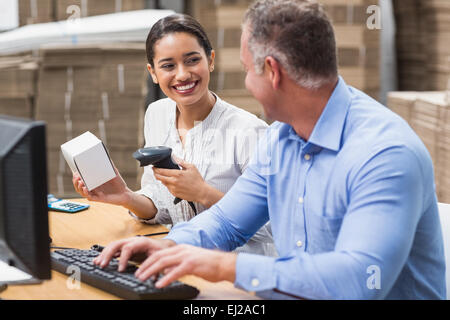 Manager, die Scan-Feld während ihrer Kollegin Tippen auf laptop Stockfoto