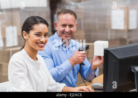Manager, die Scan-Feld während sein Kollege auf Laptop tippen Stockfoto