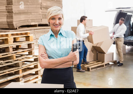 Warehouse Manager Holding Scanner mit Armen gekreuzt Stockfoto