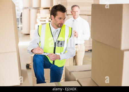 Auslieferungsfahrer Überprüfung seiner Liste in Zwischenablage Stockfoto