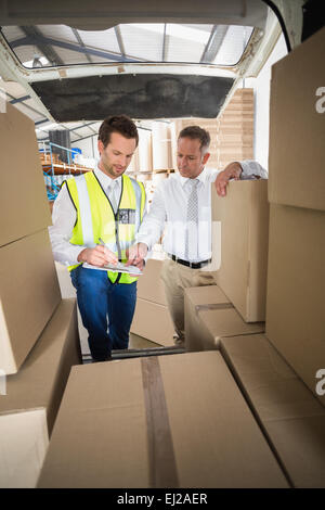Auslieferungsfahrer Überprüfung seiner Liste in Zwischenablage Stockfoto