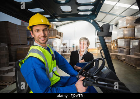 Lagerarbeiter und seinem Manager in die Kamera Lächeln Stockfoto