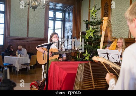 Musiker in Trachten spielen in einem Café am Adventmarkt im Palais Niederösterreich-Wien, Österreich Stockfoto