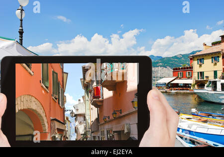 Konzept - Reisen Tourist nimmt Bild der schmalen Straße bis zum Gardasee in Malcesine Stadt, Italien auf Smartphone, Stockfoto