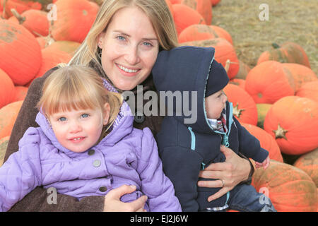 attraktive Mutter mit Kindern Porträt im Kürbis Stockfoto