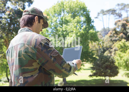 Soldat auf Tablet-pc im park Stockfoto