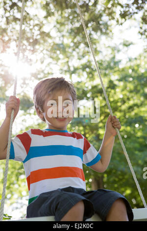 Glücklich kleiner Junge auf einer Schaukel im park Stockfoto