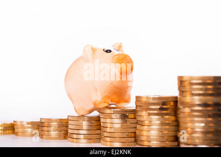 Piggy Bank stehend auf Haufen von Münzen. Stockfoto