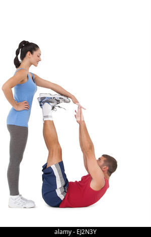 Trainer helfen ihre Client-Stretch-Beine Stockfoto