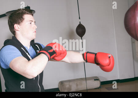 Ein Boxer dabei einige Training am Boxsack in einem Fitnessstudio Stockfoto