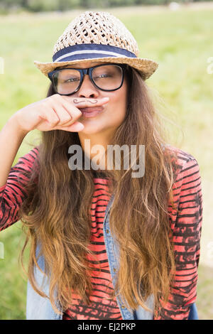 Hübsche Brünette im Park mit Schnurrbart auf finger Stockfoto
