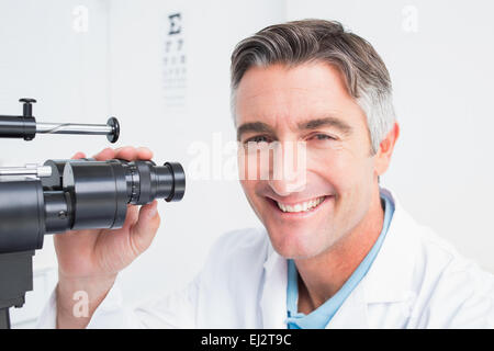 Glücklich Optiker mit Spaltlampe in Klinik Stockfoto