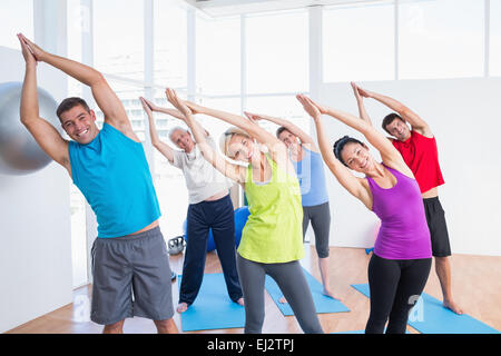 Glückliche Menschen tun stretching Übung im Yoga-Kurs Stockfoto