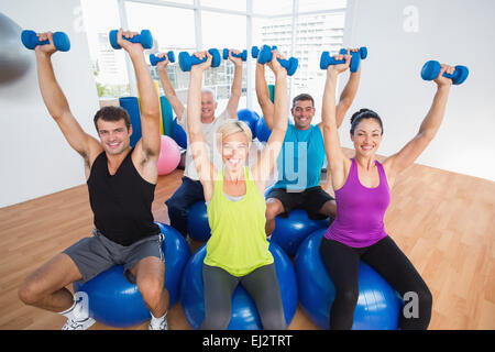 Menschen heben von Gewichten im Sportunterricht Stockfoto