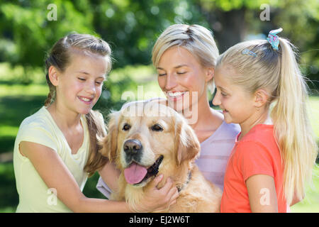 Glückliche Familie mit ihrem Hund spielen Stockfoto