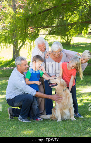 Glückliche Familie, die ihren Hund streicheln Stockfoto