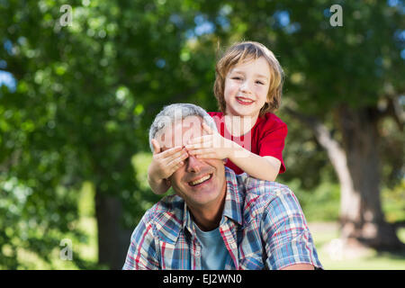 Glückliche kleine Junge versteckt seine Fatherss Augen mit den Händen Stockfoto