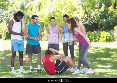 Fitness-Gruppe, die Förderung der Mann tut Sit Ups Stockfoto