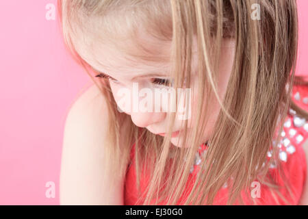 Eine traurige kleine Puppe Mädchen in rosa Hintergrund Stockfoto