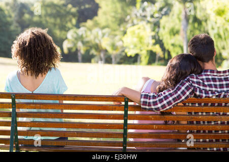 Einsame Frau sitzend mit paar im park Stockfoto