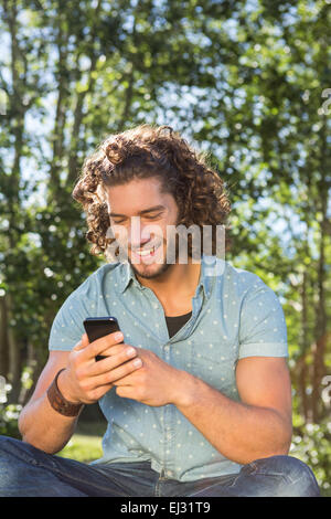 Junger Mann mit Smartphone im park Stockfoto