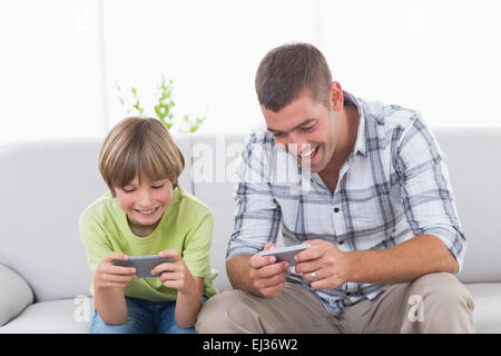 Vater und Sohn spielen auf dem Handy Stockfoto