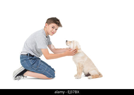 Junge streicheln Hund kniend Stockfoto