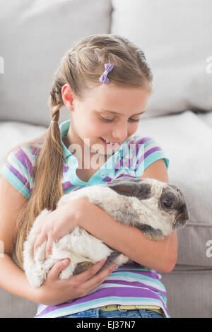 Mädchen mit Kaninchen in Wohnzimmer Stockfoto