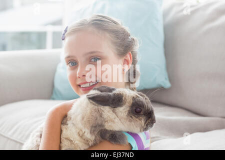 Glückliches Mädchen halten Kaninchen im Wohnzimmer Stockfoto
