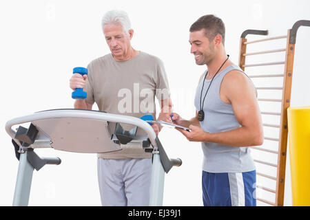 Senior woman auf Laufband mit trainer Stockfoto