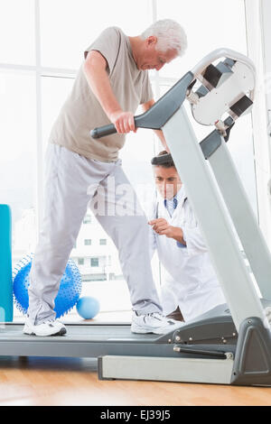 Senior woman auf Laufband mit Therapeuten hocken Stockfoto