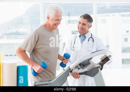 Senior woman auf Laufband mit Therapeuten Stockfoto