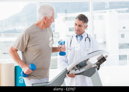 Senior woman auf Laufband mit Therapeuten Stockfoto