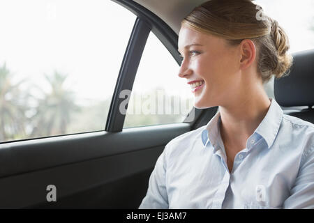 Lächelnde junge Geschäftsfrau in ihrem Auto sitzen Stockfoto