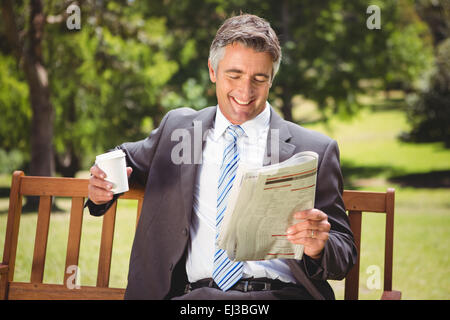 Geschäftsmann Zeitunglesen im park Stockfoto
