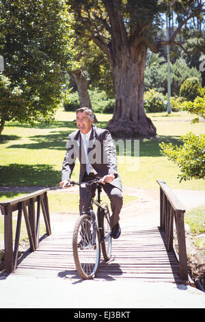 Geschäftsmann Reiten Fahrrad im park Stockfoto