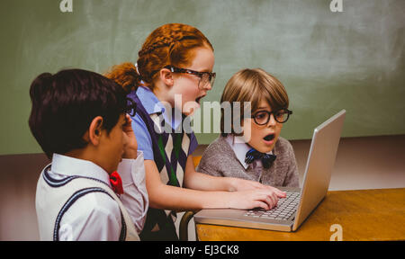 Schockiert kleine Schulkinder mit laptop Stockfoto