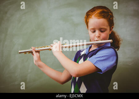 Niedliche kleine Mädchen Flötenspiel im Klassenzimmer Stockfoto