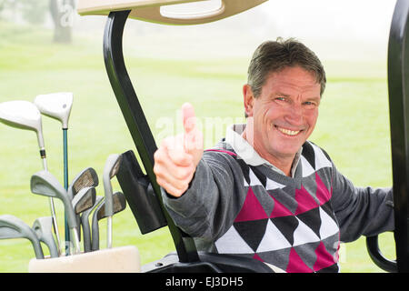 Glücklich Golfer Fahrt mit seinem Golfbuggy lächelnd in die Kamera Stockfoto