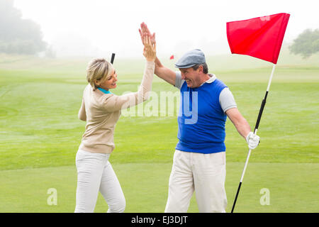 Golf paar hohe Fiving auf dem Golfplatz Stockfoto