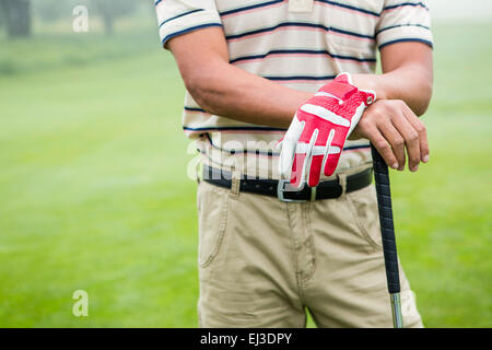 Golfer stehen und stützte sich auf seinen Verein Stockfoto