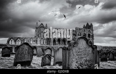 Whitby Abtei, North Yorkshire mit Friedhof im Vordergrund und eine dunkle Stimmungsvoller Himmel. Stockfoto