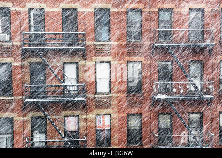 New York City, New York State, USA, Freitag, 20. März 2015; Schnee am ersten Tag des Frühlings bringt Out ein Schneepflug an das Trikot Pendlerverkehr auf 11th Avenue & Einlagen eine Schale von weiß auf alten Ziegel Mietshaus Feuerleitern während ein Streifenwagen in der Ecke Deli gebunden hält zu holen einige heißen Kaffee in der Stadt Hells Kitchen Nachbarschaft Credit: Dorothy Alexander/Alamy Live News Stockfoto